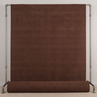 Hel vy av brunt manchestertyg Huggy upphängt på tygställning.