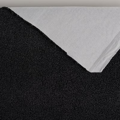 Svart möbeltyg med synlig baksida och mjuk fårpälsliknande yta