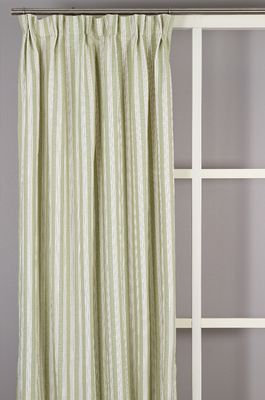 Vegani randiga gardiner i grönt och vitt upphängd vid ett fönster med grå vägg och vit karm, visar tygets naturliga fall