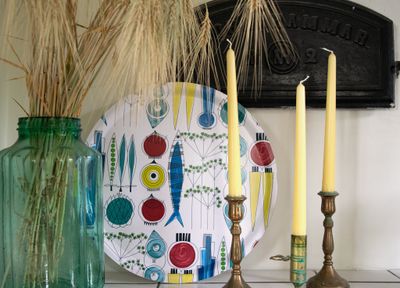 Rund Picknick-bricka med Marianne Westmans klassiska mönster tillsammans med ljusstakar och torkade sädesax.