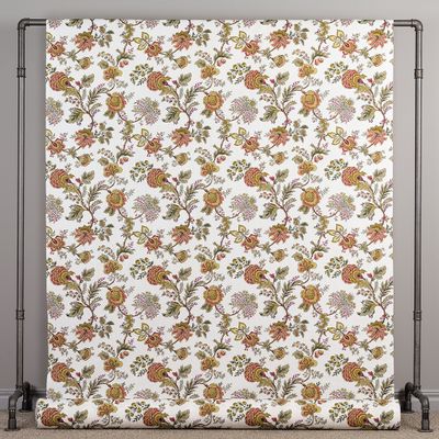 Tyg uppspänt som visar ett klassiskt blommönster i vinrött och grönt