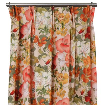 Närbild på Capucine orange gardin som visar det färgstarka blommönstret i orange, rött och grönt.
