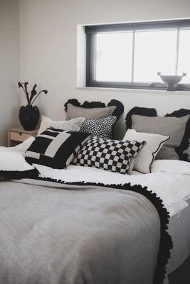 Velora svart duk med svart volang använd som textil på bäddad säng