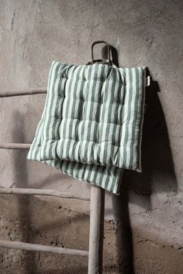 Randig sittdyna i grönt och offwhite upphängd på trästege, med handtag och mjuk stoppning