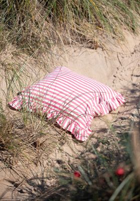 Svea cerise randigt kuddfodral med volang från Fondaco, ceriserandigt kuddfodral i sand och strandgräs