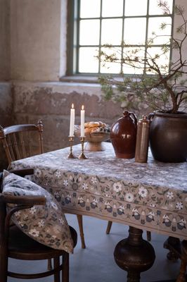 Julefrid grön julduk med beige botten på dukat bord med ljus, granris och ekorrar i kantbården
