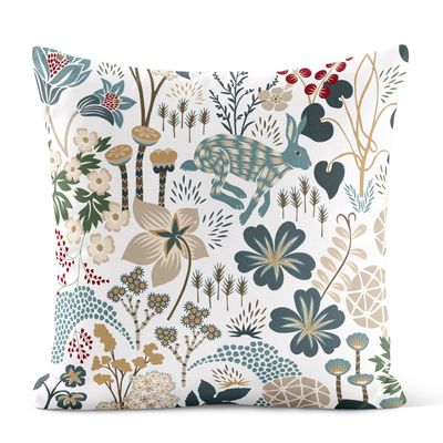 Lyckeflykt turkos kuddfodral formgivet av Hanna Werning med hare, blommor och växtlighet i turkosa, gröna, beige och röda toner.