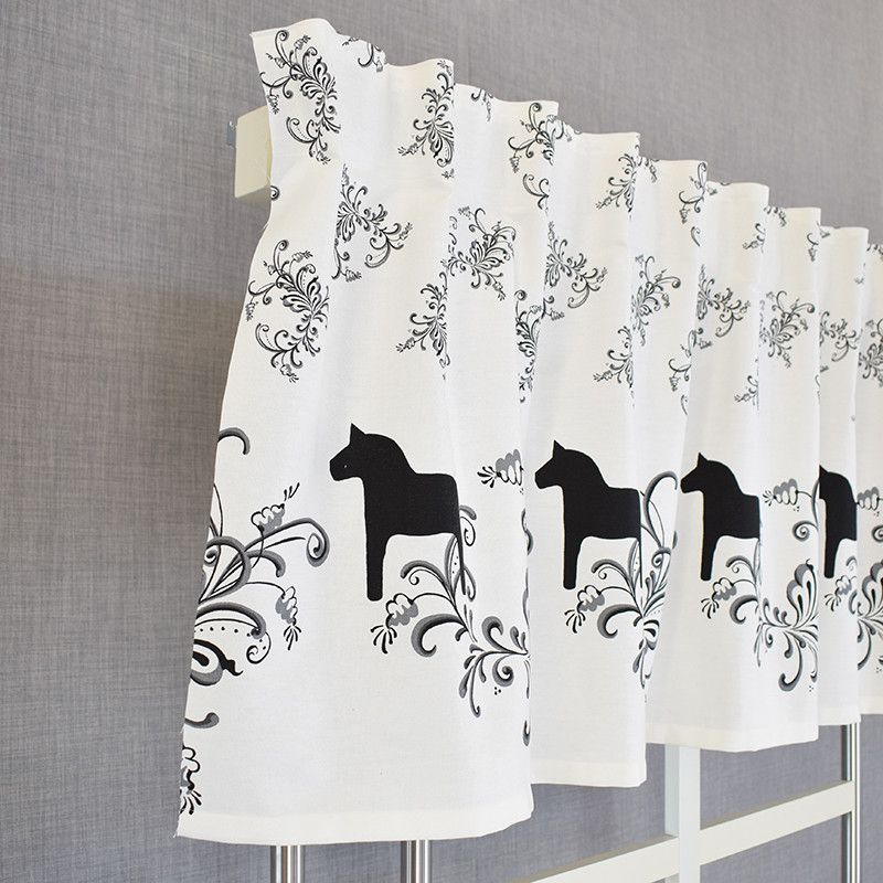 Gardin kappa på metervara med vit botten och svarta dalahästar med svensk design