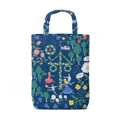 Midsommardans Blå tygkasse med motiv av midsommarstång, dansande barn, svenska flaggor och sommarblommor på mörkblå bakgrund.