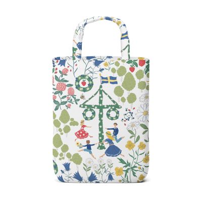 Vit tygkasse med motiv av midsommarstång, dansande barn, svenska flaggor och sommarblommor i nordisk stil.