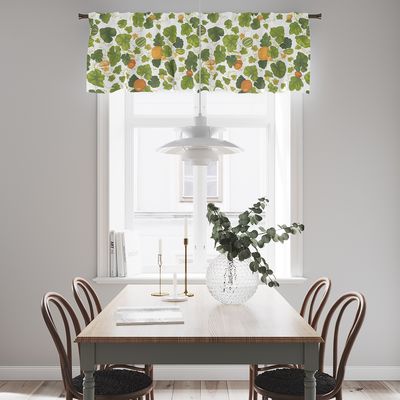 Pumpor grön gardinkappa med gröna blad och pumpor upphängd i ett ljust kök med matbord och stolar.