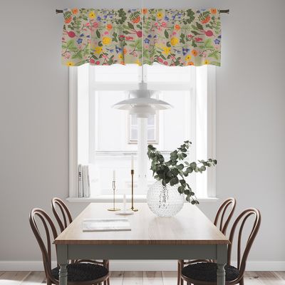 Hedemora culla multi gardinkappa med färgstarkt blommönster upphängd i ett ljust kök med matbord och trästolar.