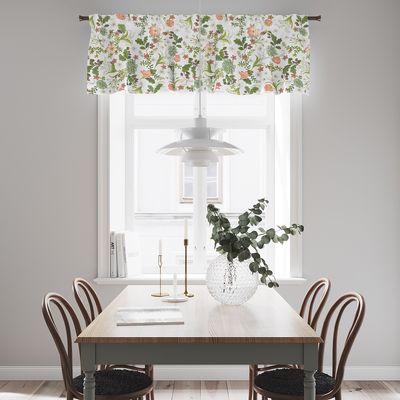 Liljebacken grön gardinkappa med botaniskt mönster upphängd i ett ljust fönster ovanför ett matbord.