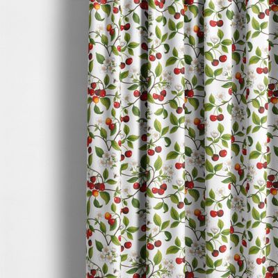 Körsbärsdalen från Arvidssons Textil upphängt som gardin med röda körsbär, vita blommor och gröna blad.
