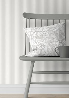 Poème d’amour silver kuddfodral med Stig Lindbergs mönster i silver metallic på vit botten, placerat på en stol.