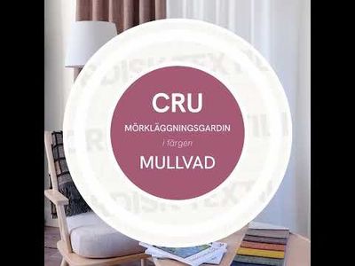 Video med mjuk panorering i vardagsrumsmiljö med Cru mullvad mörkläggningsgardin, ljus fåtölj med prickig kudde, pläd, kaffekopp med lätt ånga och tygprover på runt bord.