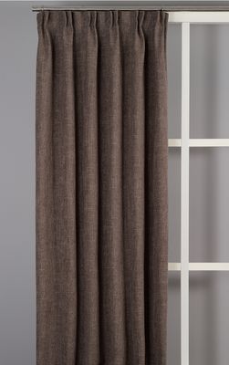 Brun 100% mörkläggande gardin i dubbel bredd monterad i fönster med stilren inredning.