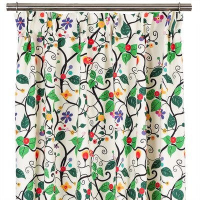 Närbild på Rauma Garden gardiner med färgstarka blommor och slingrande svarta växter mot krämvit bakgrund