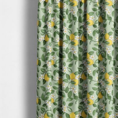 Gardiner i grönt tyg med citroner som hänger i mjuka veck i ett ljust rum