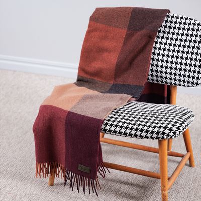 Rubinröd Pleasant Ruby filt över fåtölj i varm och stilren miljö