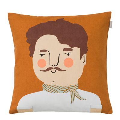 Möt Carlos - ett kuddfodral med grafiskt ansikte, mustasch och scarf i rostfärgade nyanser