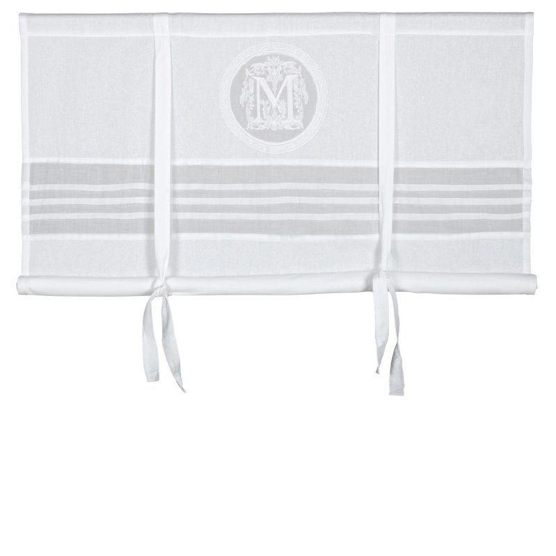 Vacker gammeldags vit hissgardin med knytband med en dekorativt monogram i mitten av gardinen.