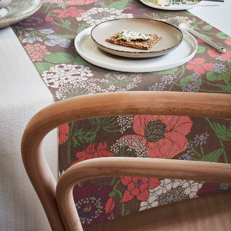 Härlig bordslöpare 'Blomsterfång' 35X140 cm, präglad av en mångfald av blommor i varma toner, tillverkad i Sverige och GOTS-märkt.