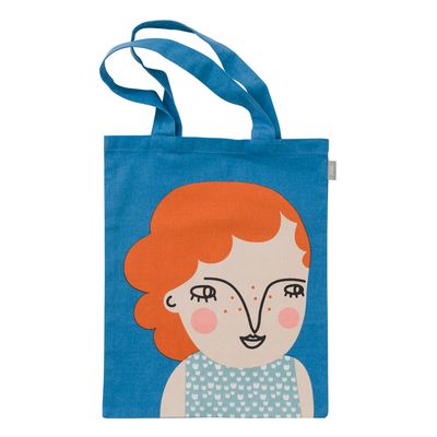 Blå tygkasse med illustration av en person med orange hår och dekorativt motiv på framsidan