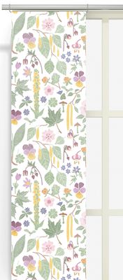 Kungsljus panelgardiner med blomstermönster upphängda i fönster och släpper igenom mjukt ljus.