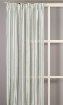 Fullängdsbild av Disa gardin med ljusgröna ränder, upphängd framför ett fönster med grå vägg som bakgrund.