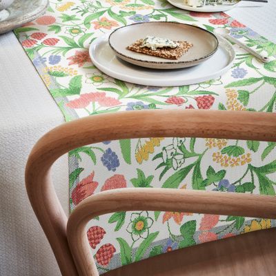 Hållbar bordslöpare med detaljerat blommönster i pastell, framställd i Sverige enligt GOTS-standarden från ekologiska fibrer.
