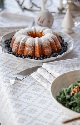 Närbild på Åttebladsrose beige duk med åttebladrosmönster i ljusa toner