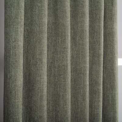 Närbild av grön mörkläggningsgardin med tydlig textil struktur.
