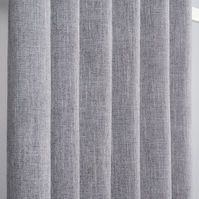 Närbild av grå mörkläggningsgardin som visar den vävda och texturerade ytan.
