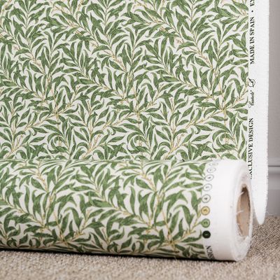 Tyg med vit botten, gröna blad och gula kvistar