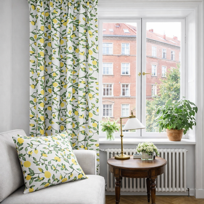 Kuddfodral i Citronträd gul tyg med citroner och gröna blad placerat i en soffa.