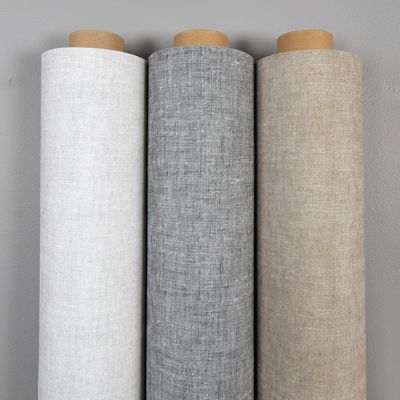 Tygrullar av Style vaxduk i tre färger upprullade mot en grå vägg