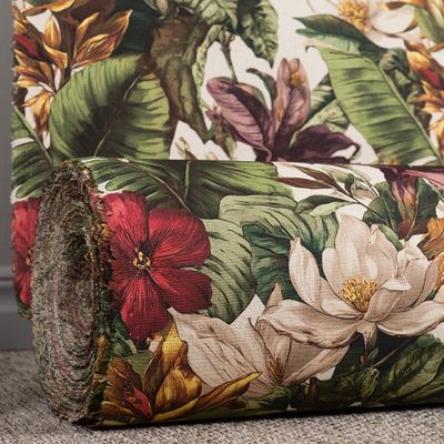 Ihoprullat tyg med motiv i grönt, rött och beige liggande på golv