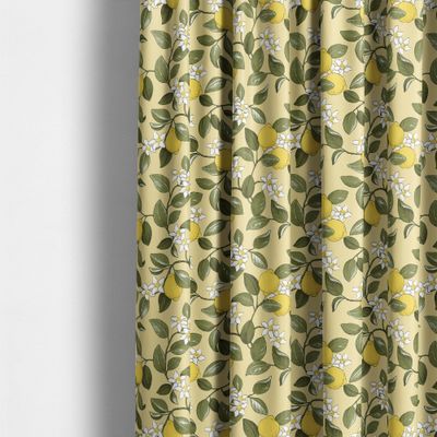 Gardiner i gult tyg med citroner som hänger i mjuka veck i ett ljust rum