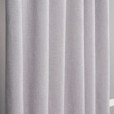 Närbild av ljusgrå mörkläggningsgardin som visar den melerade och texturerade ytan.