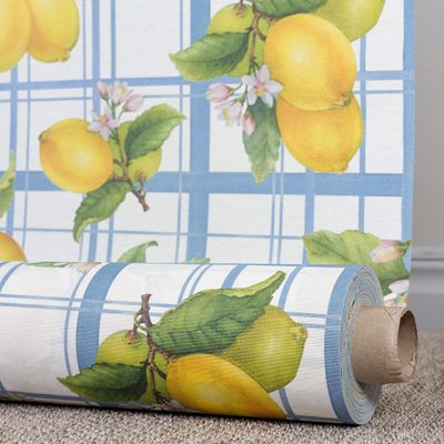 Rulle med citronmönstrad textilvaxduk med blått rutmönster och gula citroner.