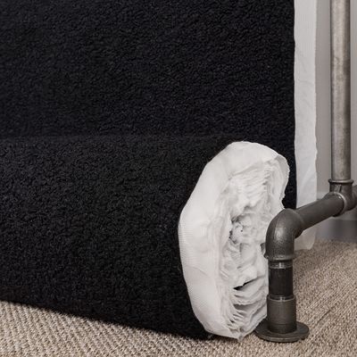 Svart möbeltyg med fårpäls känsla på rulle som visar struktur och tjocklek