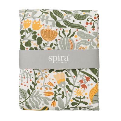 Närbild på den vikta bordsduken Myllra i gult och grönt från Spira of Sweden med pappersband
