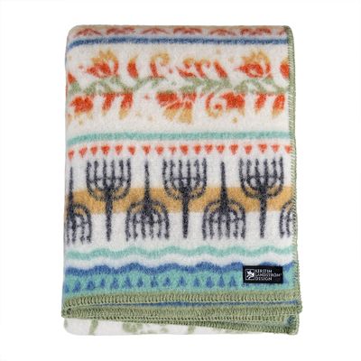 Kerstin Landström Design Kustland ullfilt i vit ull med kustinspirerat mönster i blått, grönt, gult och orange, vikt mot ljus bakgrund.