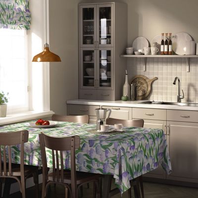 Ljuvlig blå bordsduk dukad på ett matbord i kök med blommigt mönster i blå och gröna toner