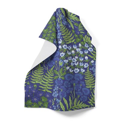 Blå handduk med blommor och gröna blad