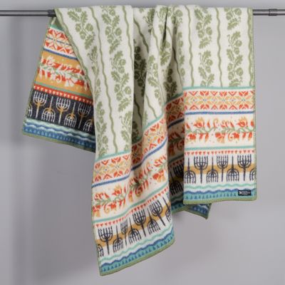 Kustland ullfilt upphängd som visar folkliga mönster med ekblad och dekorativa bårder i harmoniska färger.