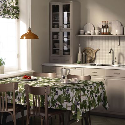 Fikonträd grön bordsduk på matbord i kök, dukad med porslin och kaffekanna