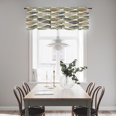 Fönsterkappa i bladmönster i grönt och beige som hänger över ett ljust fönster i matrum