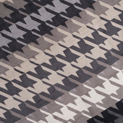 Detaljbild av houndstooth-mönster i neutrala färger.
